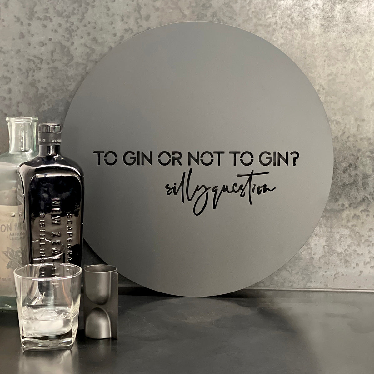 "To gin or not to gin, silly question" The perfect gift for a friend or just for you. 40cm diameter of premium grade stainless steel electro coated in matt black. Suitable for indoors and outdoors. Words are cut out of the steel. Comes ready to hang using hooks or screws (not provided) on custom cut hanging blocks. These make the art pop out from the wall for effect.