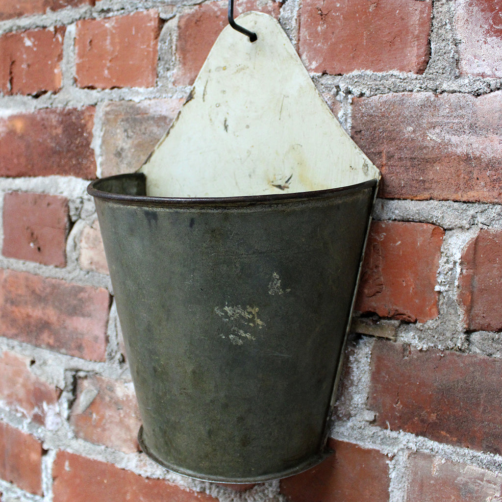 This small vintage florists wall vase makes a wonderful planter, or a beautifully understated vase. Or alternatively fill with seasonal fresh blooms and greenery to create something unique.   Suitable for outdoor use, however they will age and some surface rust may occur over time. This can be minimized by spraying with a product like Penetrol.  Handmade from recycled iron.  Size:  H 34cm x D 16cm x W 35cm