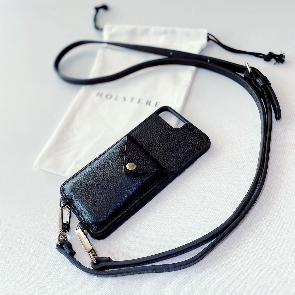 Holstere Manhattan Black Pebble Leather iPhone Case with strap. Free your hands with this luxury iPhone case crossbody in rich pebbled black, made of genuine high-quality leather. Durable construction, superior iPhone protection, and a beautiful practical design with expanded back pocket to carry more than ever. Leather is genuine real leather, sourced in an environmentally-friendly way.