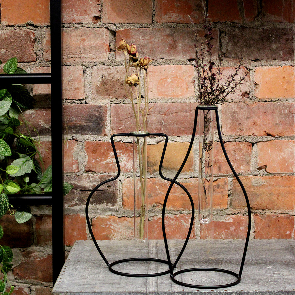 So simple but so effective. These metal frame test tubes vases look great paired together or on their own. The simple metal vase shaped frame holds one glass test tube. Perfect for a simple fresh bloom or your favourite dried arrangement.  Metal Frame Glass Test Tube  Style #1: w20 x d12 x h25cm Style #2 w15 x d12 x h30cm